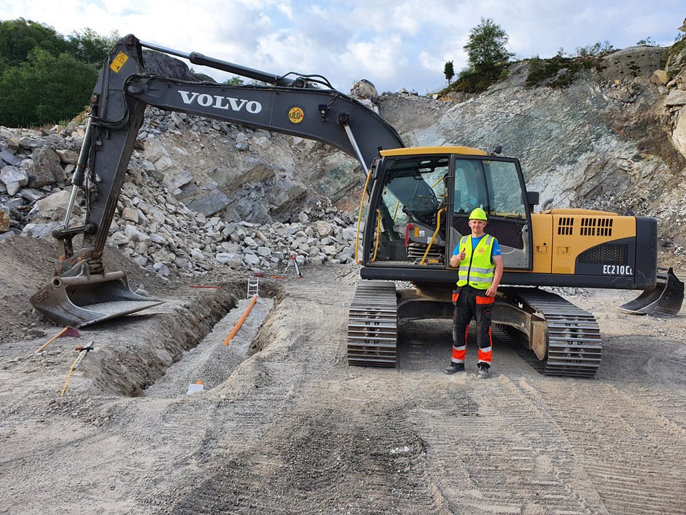 Lærling Magne Andre Skadberg foran en gravemaskin
